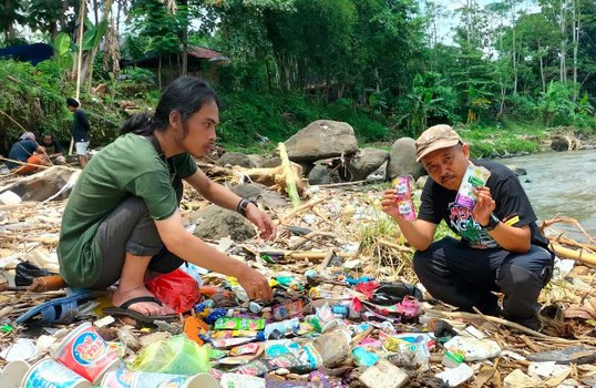 Anggota tim Ekspedisi Sungai Nusantara mengumpulkan bungkusan plastik di sepanjang bantaran Sungai Ciliwung. [Ekspedisi Sungai Nusantara]