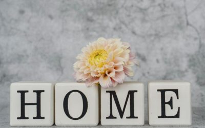 Dekorasi rumah yang stylish menampilkan huruf-huruf yang mengeja 'HOME' dengan aksen dahlia yang lembut untuk menciptakan suasana yang nyaman.