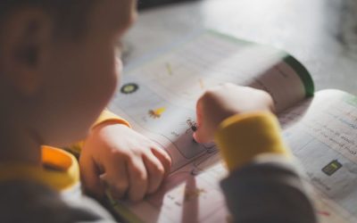 Seorang anak kecil yang fokus pada buku mewarnai, meningkatkan pembelajaran dan kreativitas.