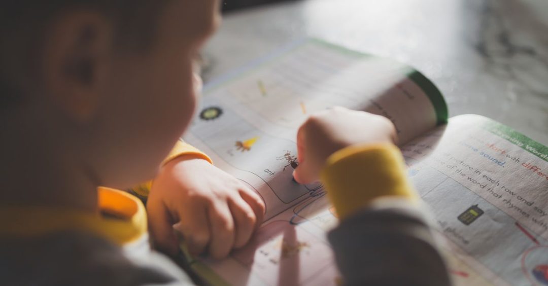 Seorang anak kecil yang fokus pada buku mewarnai, meningkatkan pembelajaran dan kreativitas.