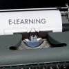 Kedekatan mesin ketik vintage yang menampilkan konsep e-learning di atas kertas.