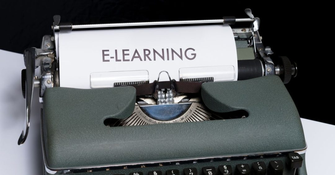 Kedekatan mesin ketik vintage yang menampilkan konsep e-learning di atas kertas.